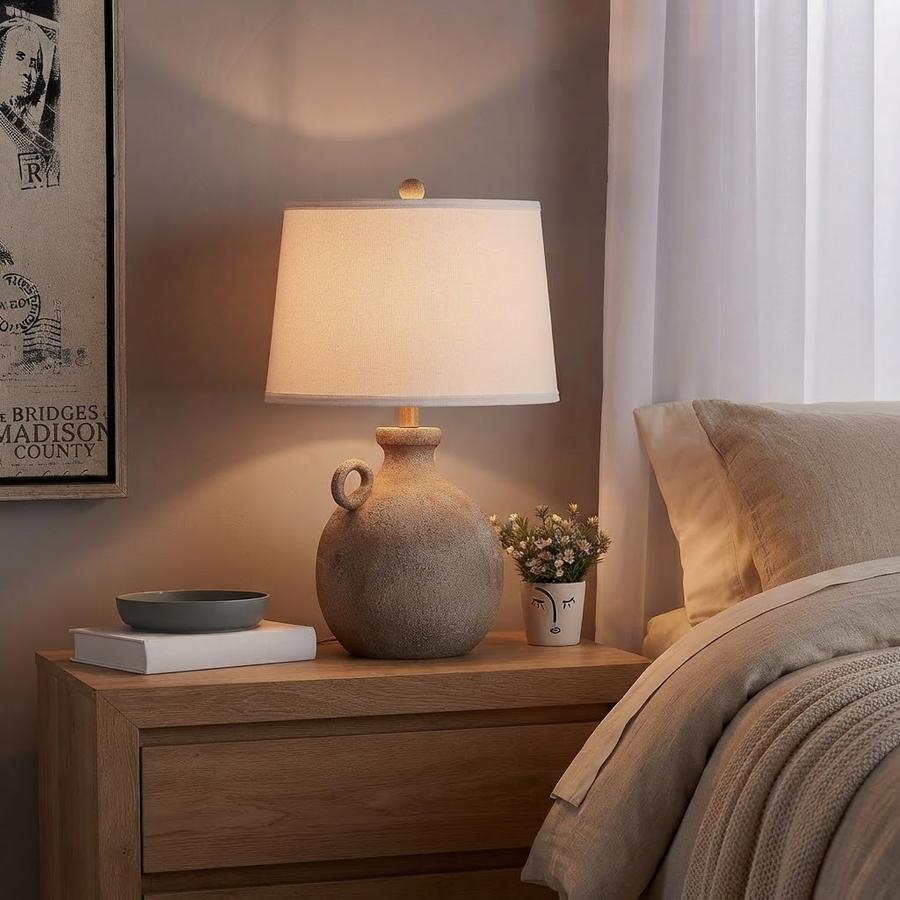 Rustic farmhouse lamp on a nightstand with a phone charging at the base